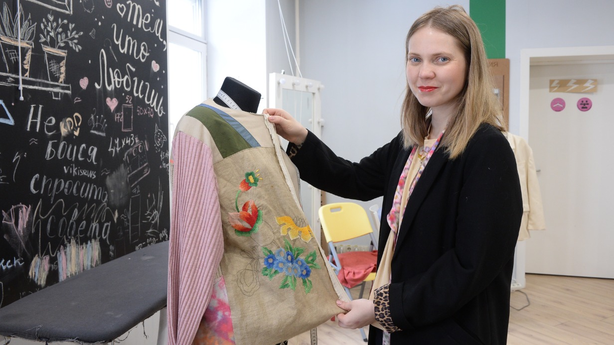 Ирина Козловских показывает жакет, сделанный в мастерской из старых тканей