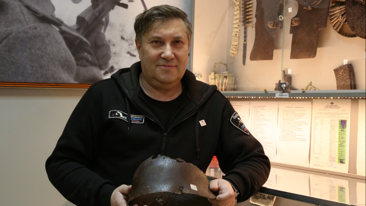 Заместитель командира поискового объединения «Память» Дмитрий Шипилов показывает каску красноармейца, в которой застряла пуля. Эти и другие экспонаты музея нашли на территории столицы