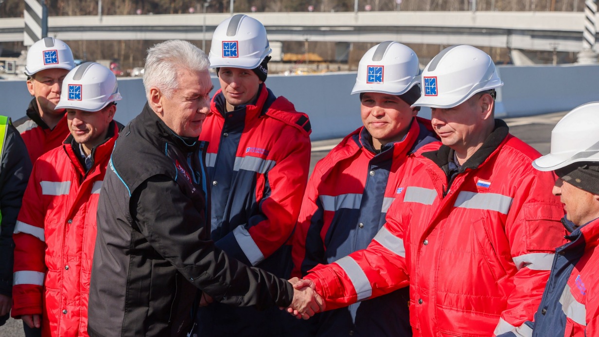 Мэр Москвы Сергей Собянин (слева на первом плане) поблагодарил строителей за хорошую работу по реконструкции транспортной развязки на пересечении МКАД с улицей Верхние Поля