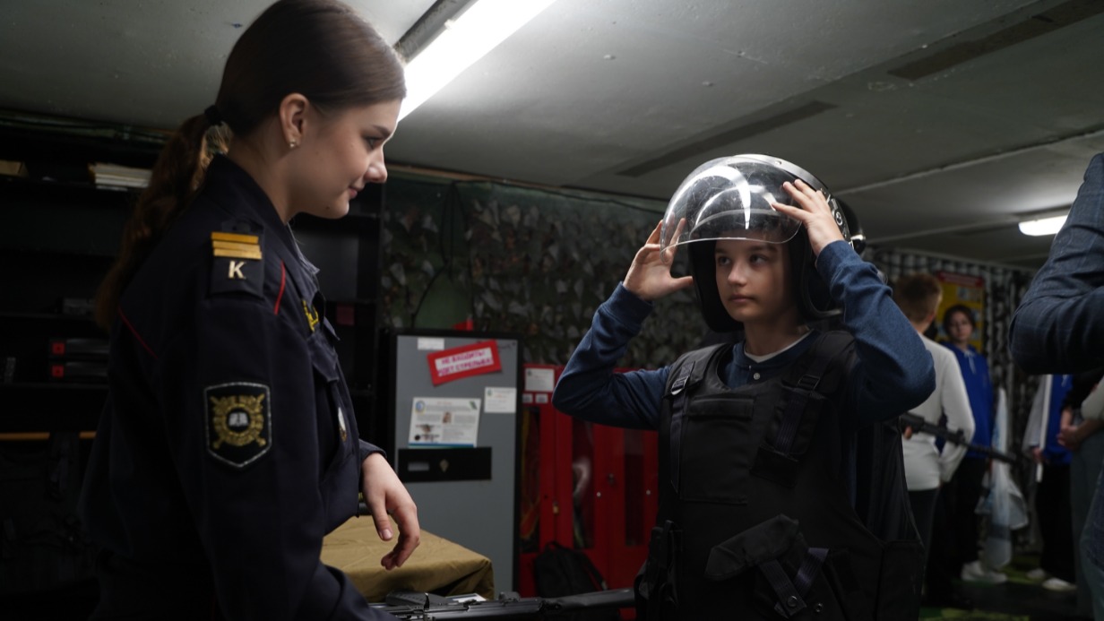 Курсант третьего курса Колледжа полиции Диана Самсонова показывает пятикласснику Ивану Васину различные виды оружия