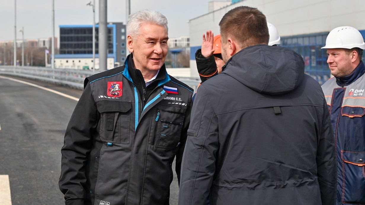 Мэр Москвы Сергей Собянин (слева) общается со строителями на открытии нового путепровода через железнодорожные пути МЦД-3 и съездов рядом с аэропортом Шереметьево