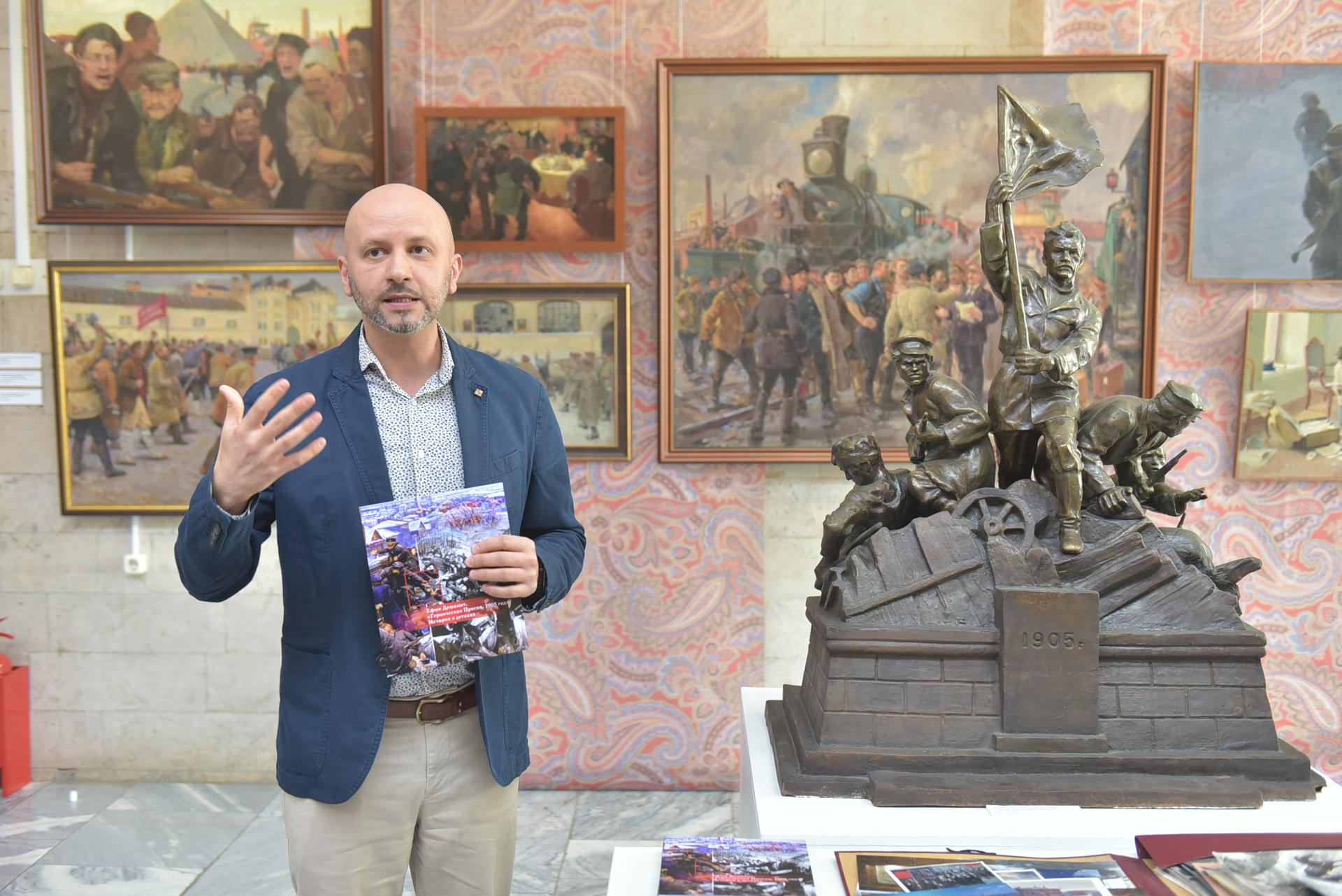 Заведующий экспозиционно-мемориальным отделом «Пресня» Юрий Быкадоров рассказывает о революции 1905 года. Справа расположена скульптура «1905 год» Олега Иконникова