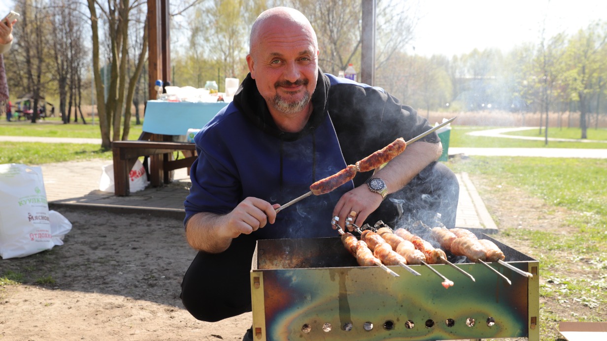 Отдыхающий Александр Урняев готовит шашлыки на пикнике в парке «Братеевская пойма» 