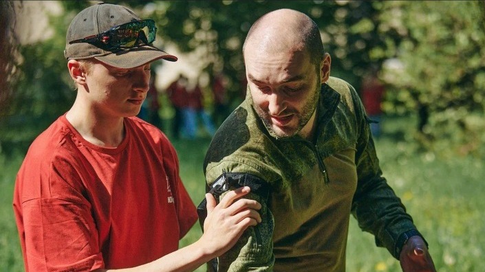 Инструктор Всероссийского юнармейского форума (справа) учит одного из его участников основам тактической медицины