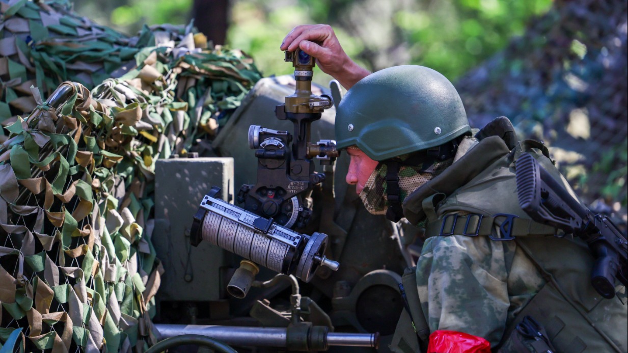 Российский военнослужащий во время работы расчета 122-миллиметровой гаубицы Д-30