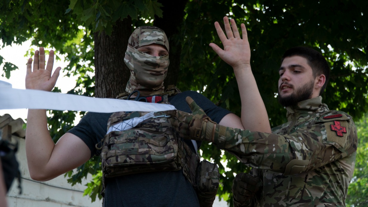 Руководитель медицинской службы региональной общественной организации «Народная Дружина» Константин Шитиков (справа) проводит для молодежи поселка городского типа Тельманово практическое занятие по оказанию первой помощи