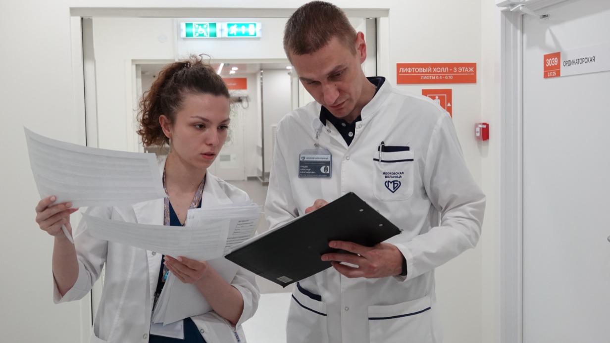 Заведующий отделением травматологии и ортопедии детского корпуса ММКЦ Александр Гришин вместе с врачом отделения смотрит историю болезни пациента