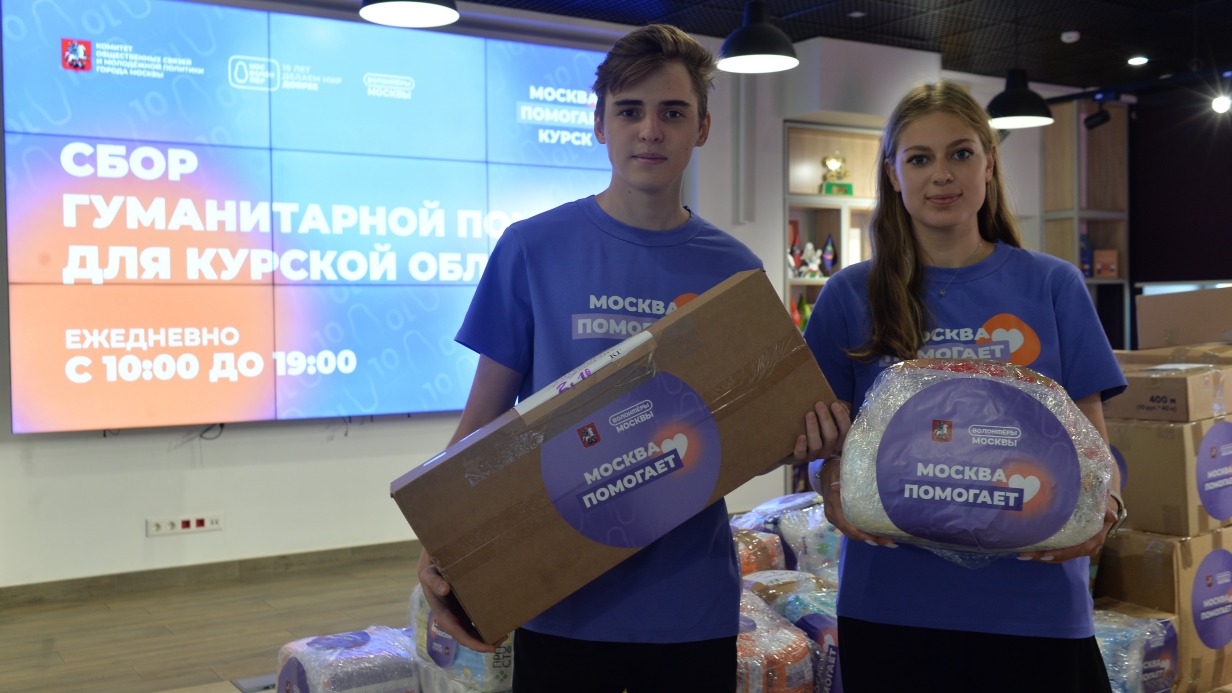 Волонтеры Егор Сацюк и Дарья Захарова переносят коробки с гуманитарной помощью из помещения флагманского ресурсного центра «Мосволонтер» в грузовик, который отвезет груз в Курскую область