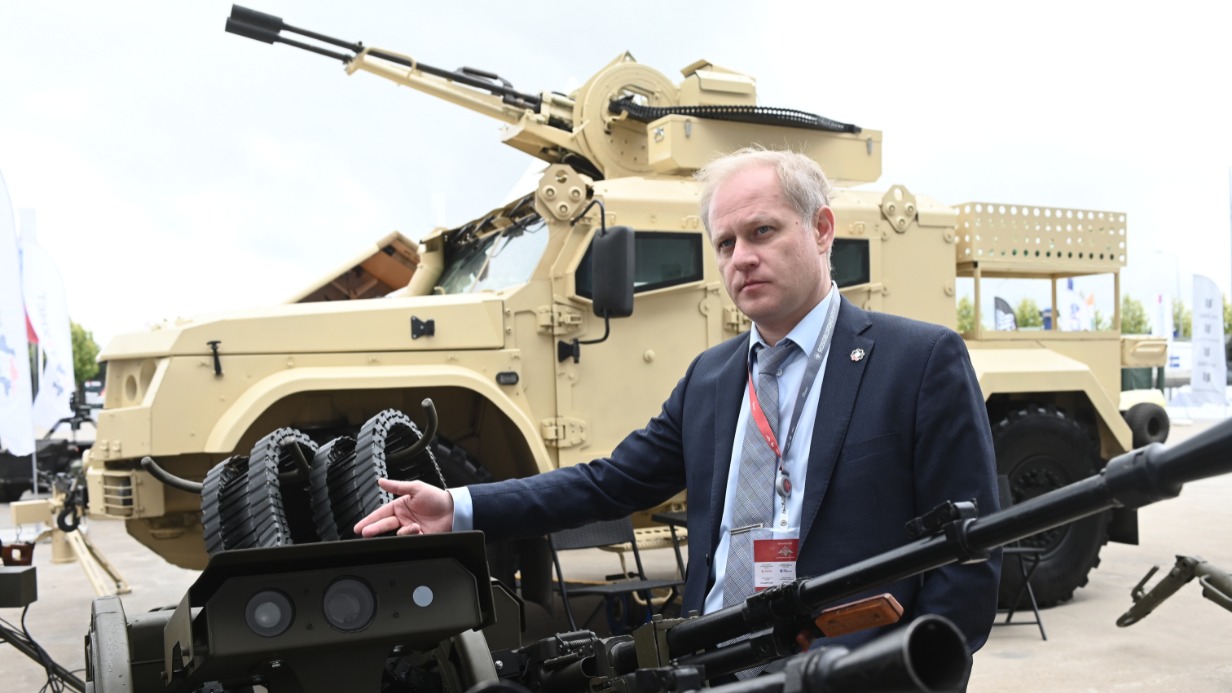 Гендиректор компании «Техмет 18» Александр Теплинский с пулеметной установкой, которая способна создать для вражеского беспилотника непроходимый огневой заслон, на выставке «Армия-2024»