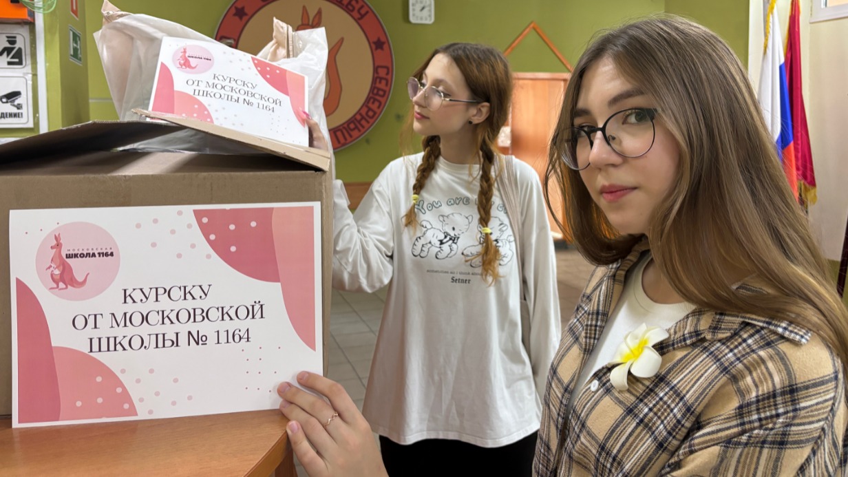 Десятиклассницы Диана Афиркина (на первом плане) и Диана Сорокина приклеивают к коробкам с гуманитарной помощью таблички «Курску от московской школы № 1164»
