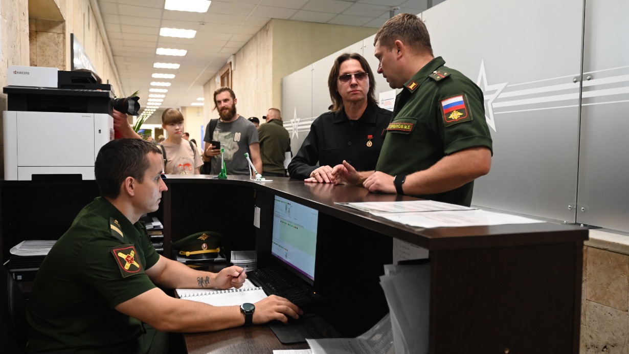 Представитель Единого пункта отбора на военную службу по контракту Михаил Горбунов (справа) во время экскурсии по зданию рассказывает солисту группы «Русский характер» Юрию Кононову, как происходит отбор кандидатов