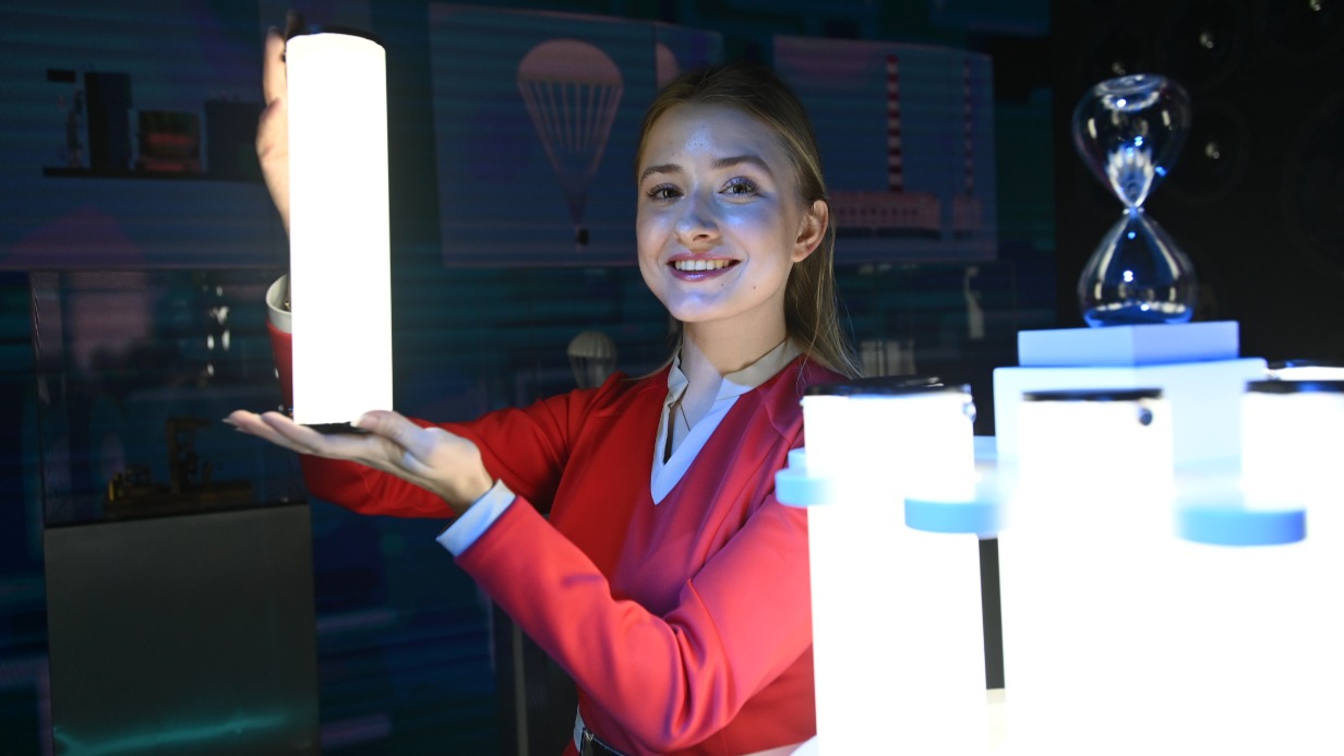 Участница мероприятия «Будь с Первыми» Александра Алексеева в роли героини книги Кира Булычова Алисы Селезневой проводит экскурсию по интерактивной экспозиции «Время Первых», рассказывая о великих отечественных изобретателях