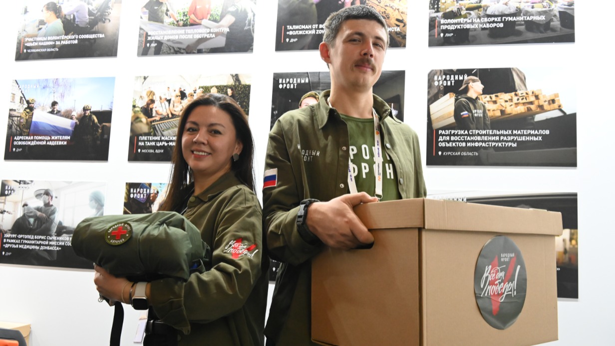 Волонтеры Общероссийского общественного движения «Народный фронт» Ирина Ким и Евгений Фролов демонстрируют специальную форму в рамках Международного форума гражданского участия #МЫВМЕСТЕ