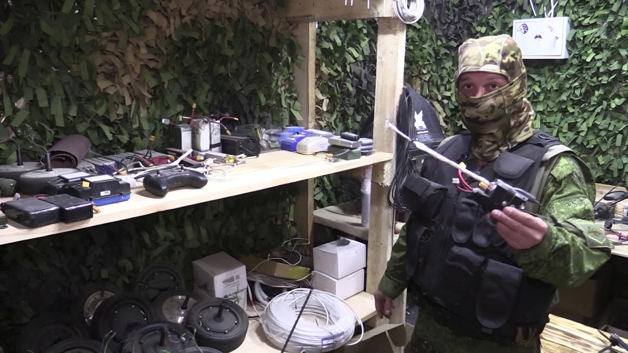 Военнослужащий группировки ВС РФ «Восток», сапер «Кнут» показывает сделанные на 3D-принтере детали дронов