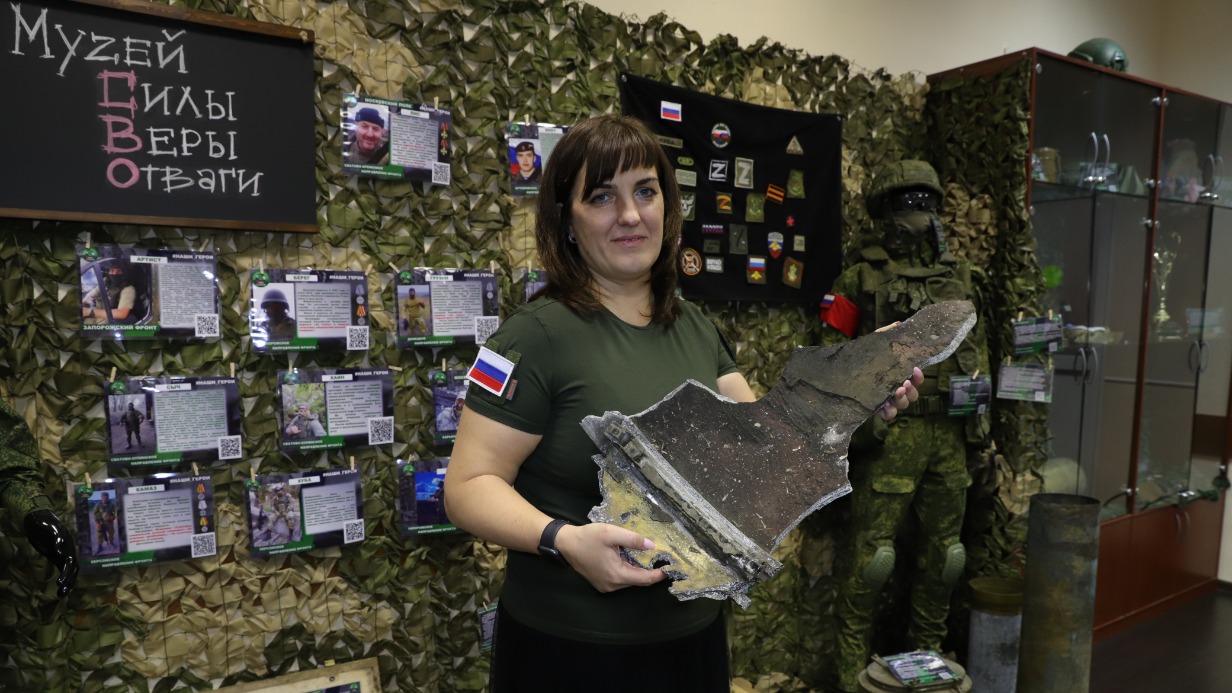 Волонтер София Баулина держит в руках осколок обшивки снаряда на открытии экспозиции «Музей Силы. Веры. Отваги»