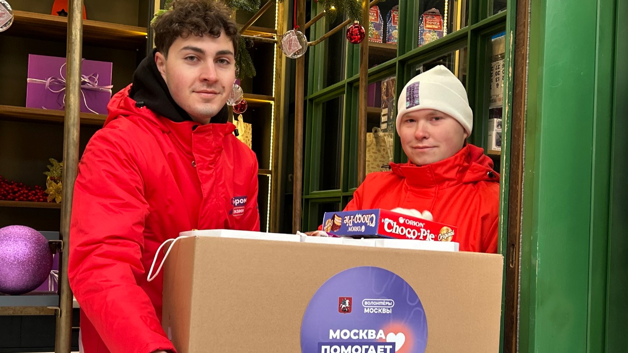 Волонтеры проекта «Мосволонтер» Вагиф Кантемиров и Александр Двойченко собирают гуманитарный груз для жителей новых регионов в рамках акции. В коробке — сладкие новогодние подарки для малышей