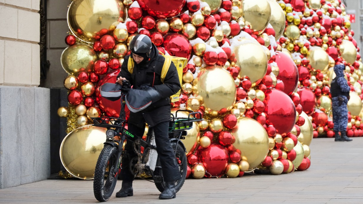 По украшенному к Новому году центру Москвы тоже регулярно ездят курьеры. Зимой они надевают специальные перчатки от холодного ветра