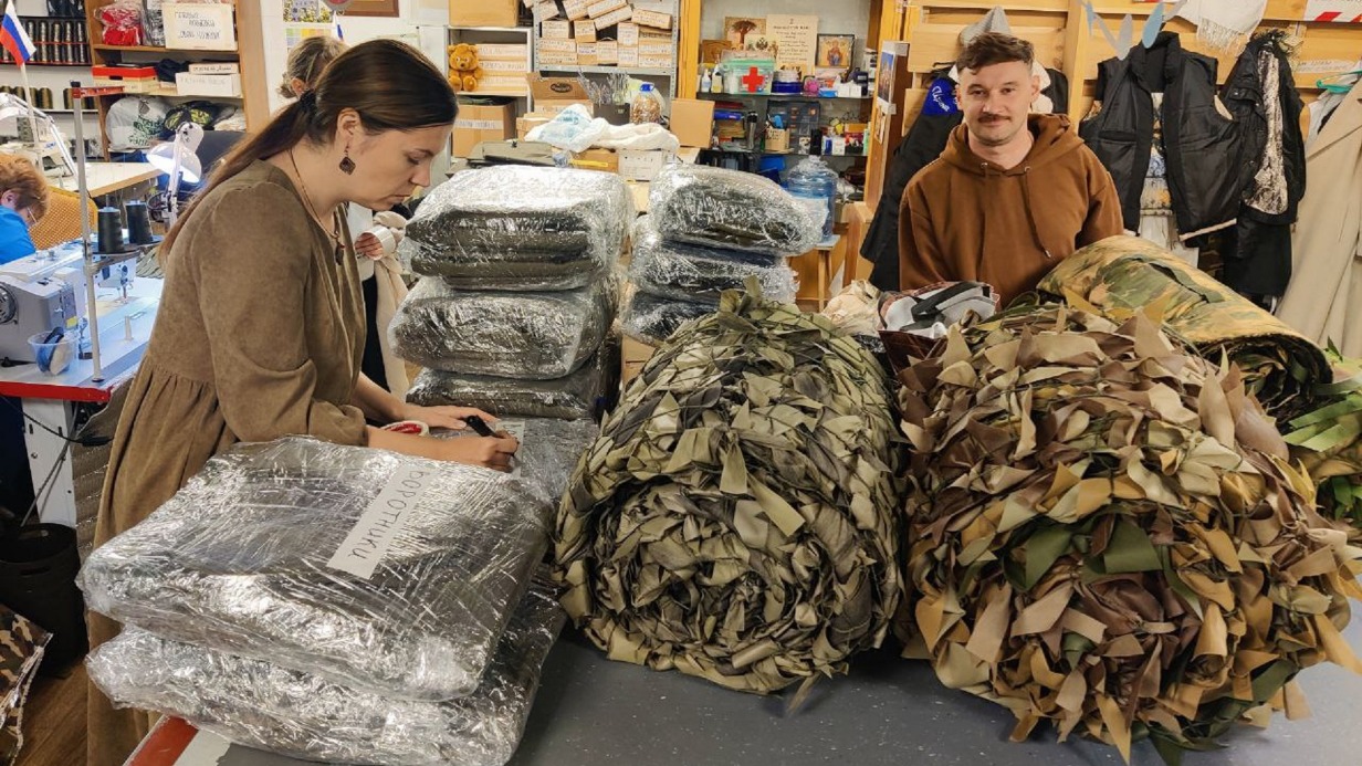Создатель движения «Миссия для своих» Макс Тичер вместе с руководителем пункта помощи фронту «ПокроV» Юлией при храме преподобного Сергия Радонежского собирают посылки для солдат на передовую