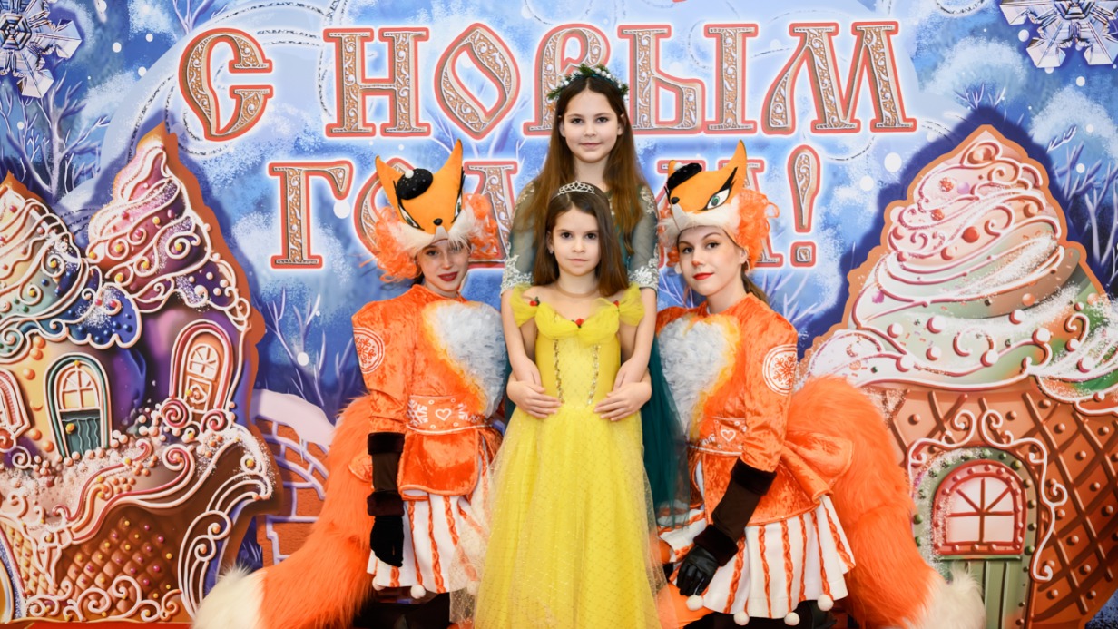 Аниматоры в костюме лисичек Алина Дементьева и Софья Турханова поздравляют с новогодними праздниками гостей Кремлевской елки Дарью и Олесю Петровых