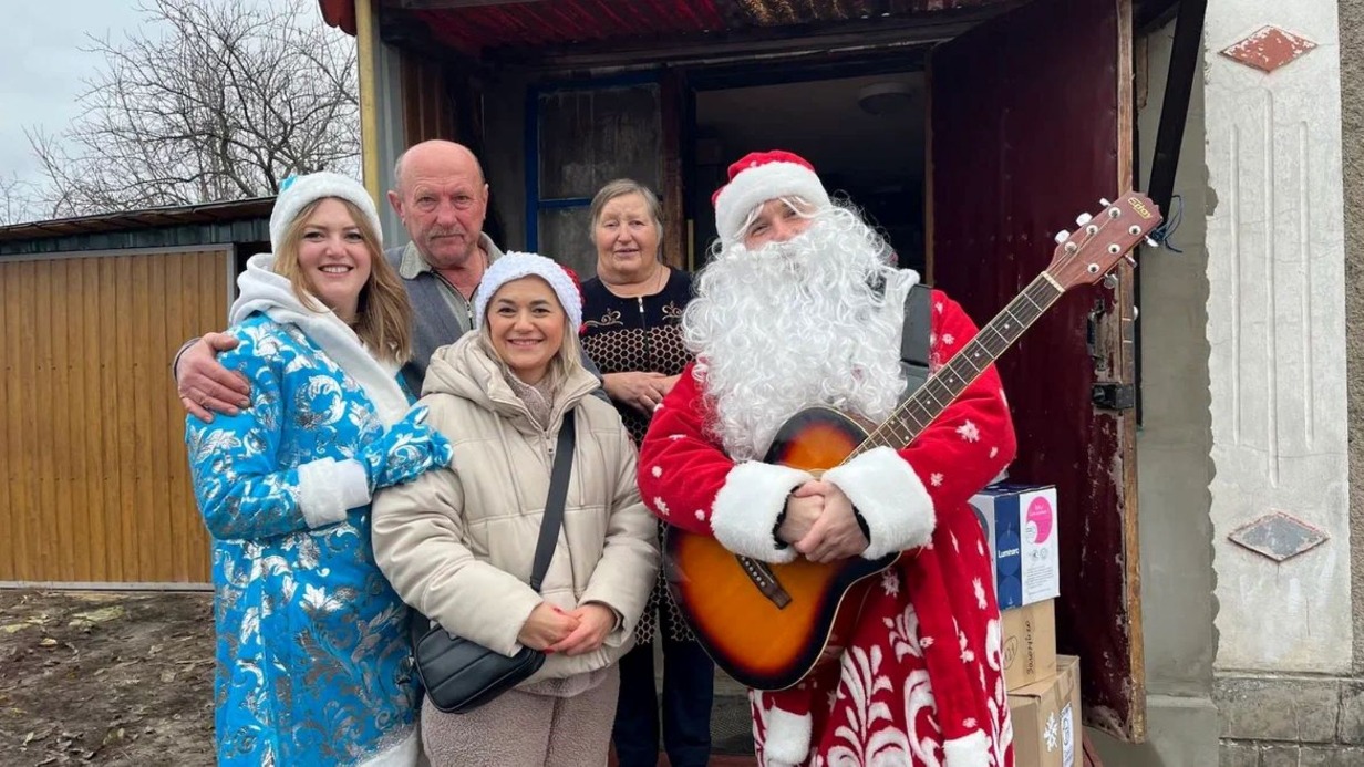 Директор фонда «Ясное дело» Анастасия Кульпетова в роли Снегурочки и артист фронтовой творческой бригады ансамбля песни и пляски Южного военного округа Министерства обороны РФ «Рубиновая звезда» Александр Кургускин поздравляют с Новым годом жителей ПВР в селе Веселом