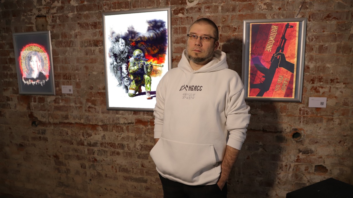 Куратор выставки «Тут совсем не так, как в твоих розовых очках» Антон Беликов показывает картину «Сила рода»