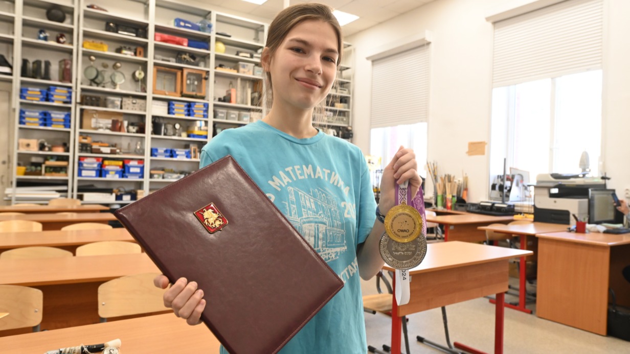 Ученица 11-го класса школы № 179 Екатерина Чуркина держит в руках благодарственное письмо мэра Москвы и медали, которые она завоевала на международных олимпиадах по астрономии и лингвистике