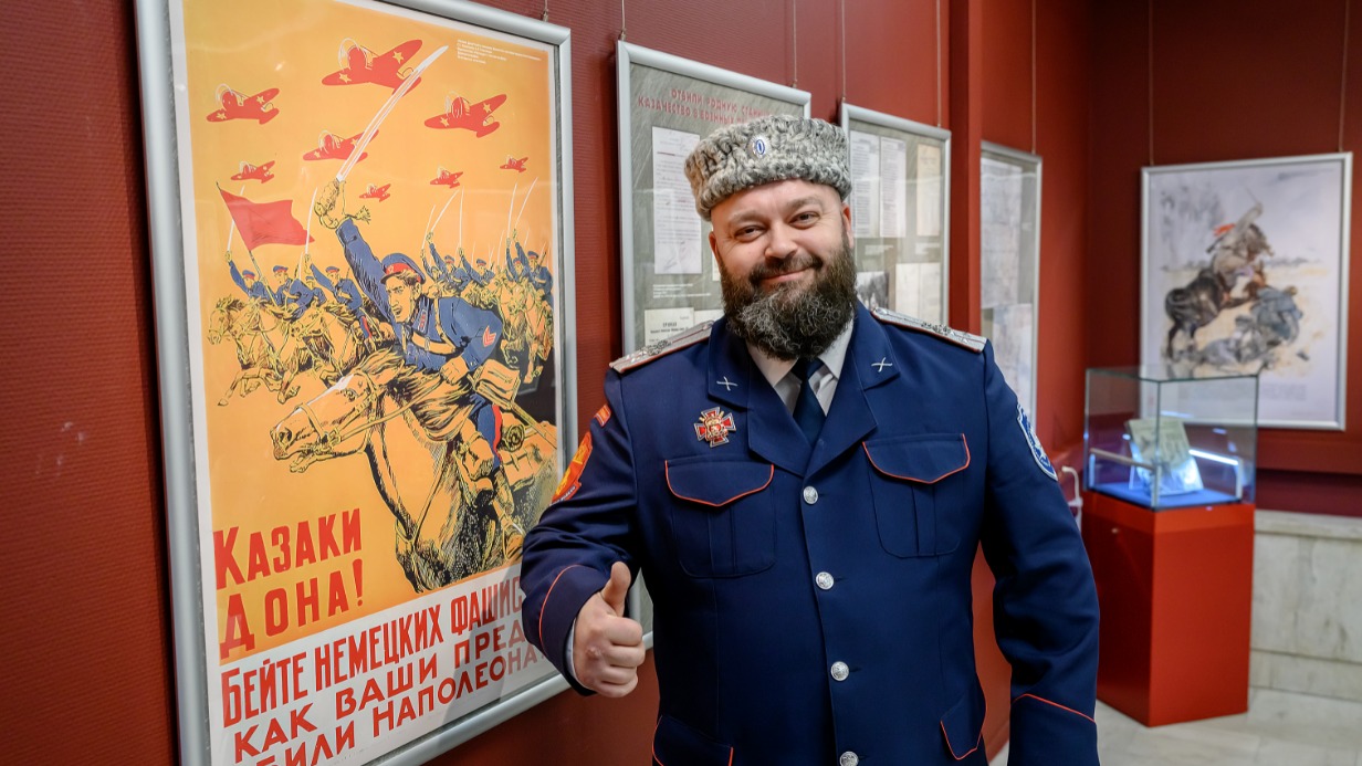 Атаман Королевского (от города Королев) хуторского казачьего общества Денис Суслов рядом с советским плакатом