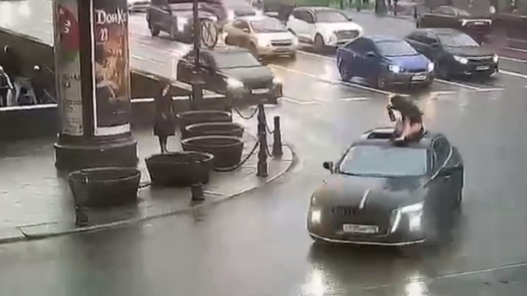Женщина с бутылкой прокатилась на крыше машины по центру Санкт-Петербурга