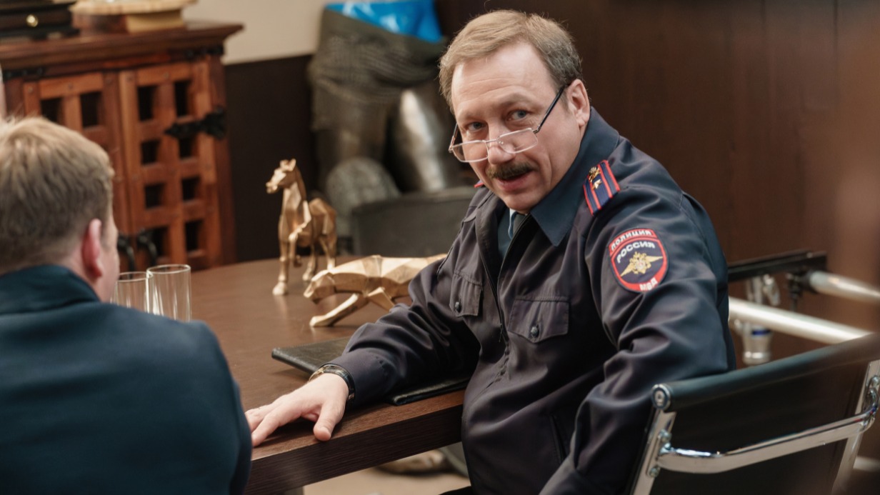 Кадр из сериала «Девушки с Макаровым»: Георгий Дронов в роли заместителя начальника ОВД Бутово Романа Жилина