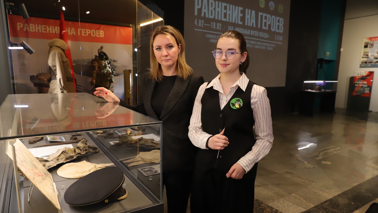 Директор детского центра Музея Победы Елена Слесаренко и ученица 10-го класса московской школы № 2006 Мария Тычинина осматривают экспозицию выставки «Равнение на героев»