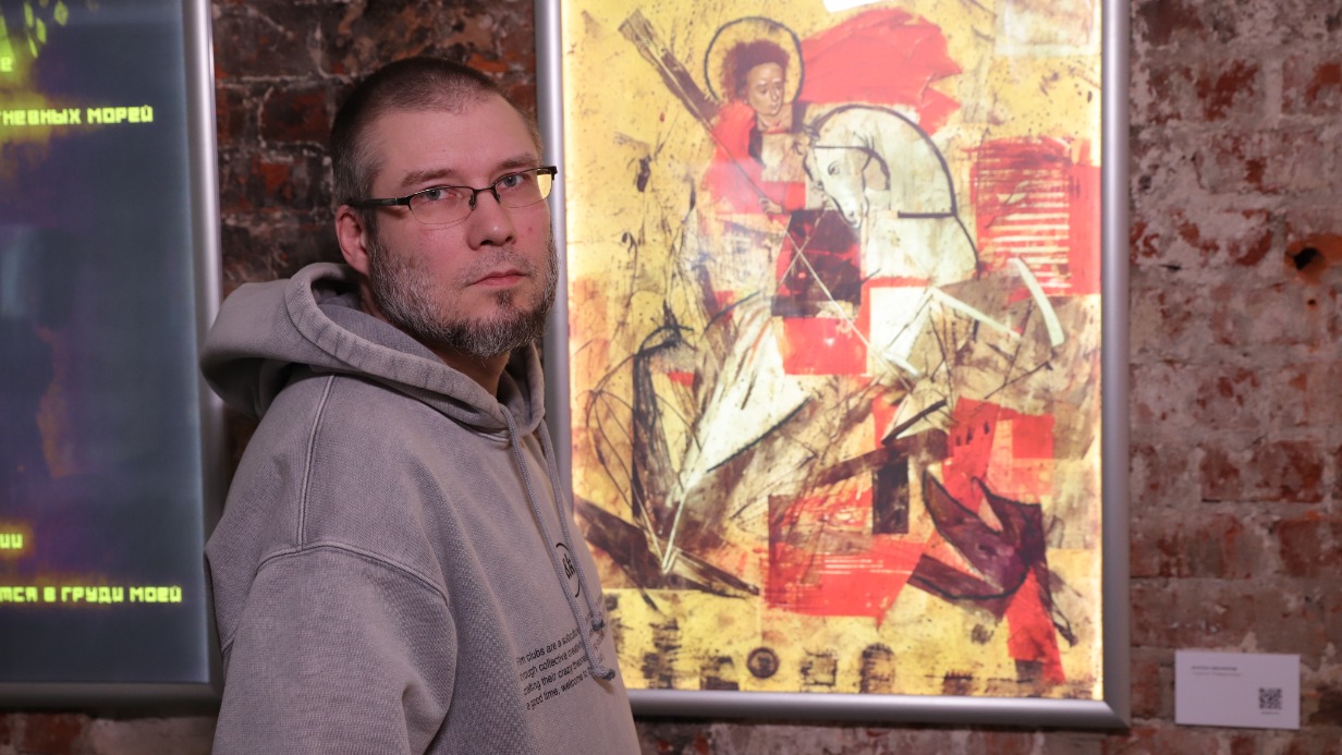 Художник Антон Беликов рядом со своей картиной «Георгий Победоносец» на выставке «Тут совсем не так, как в твоих розовых очках»