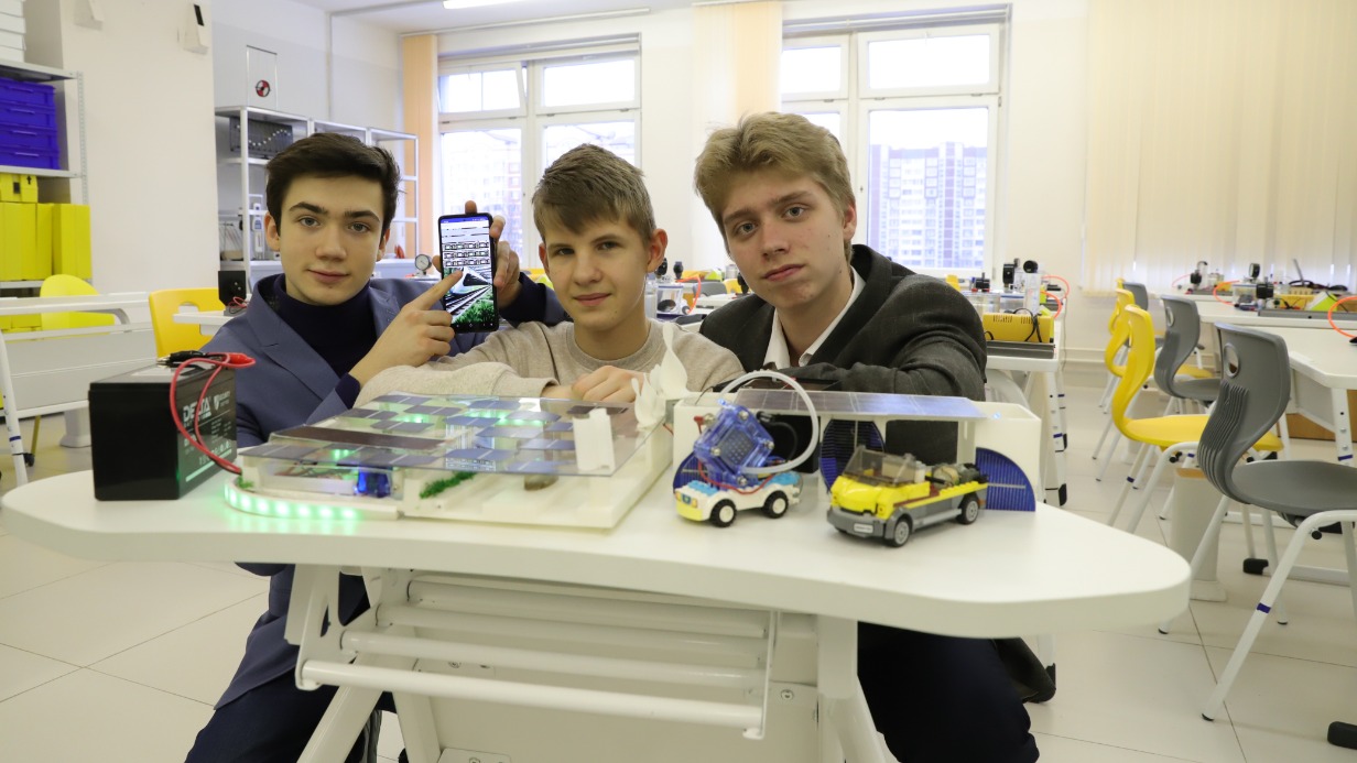 Ученики 10-го инженерного класса школы № 2045 Егор Плякин, Артем Чиликин и Артем Могучев (слева направо) показывают свой вокзал будущего