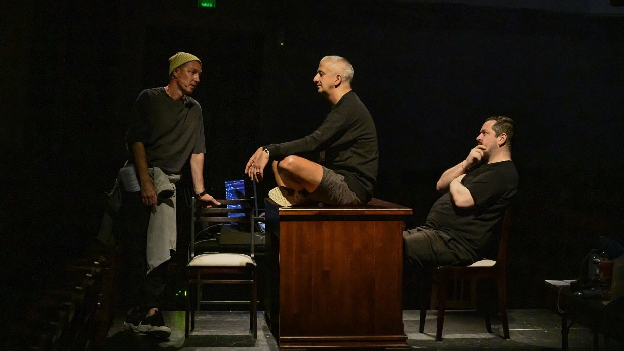 Сцена из спектакля «Новая оптимистическая». В центре режиссер Константин Богомолов в роли Провокатора, слева — Игорь Верник (Артист-анархист), справа — Лера Горин (режиссер Глотов)