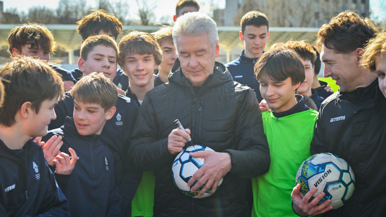 Мэр Москвы Сергей Собянин на открытии стадиона «Локомотив» сделал фото на память со спортсменами Московской академии футбола и подписал для них мяч