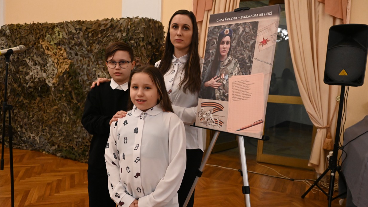 В фойе Центрального академического театра Российской армии на открытии фотовыставки Анастасия с 11-летним сыном Владиславом и 9-летней дочкой Евой у своего портрета, на котором она в форме любимого мужа