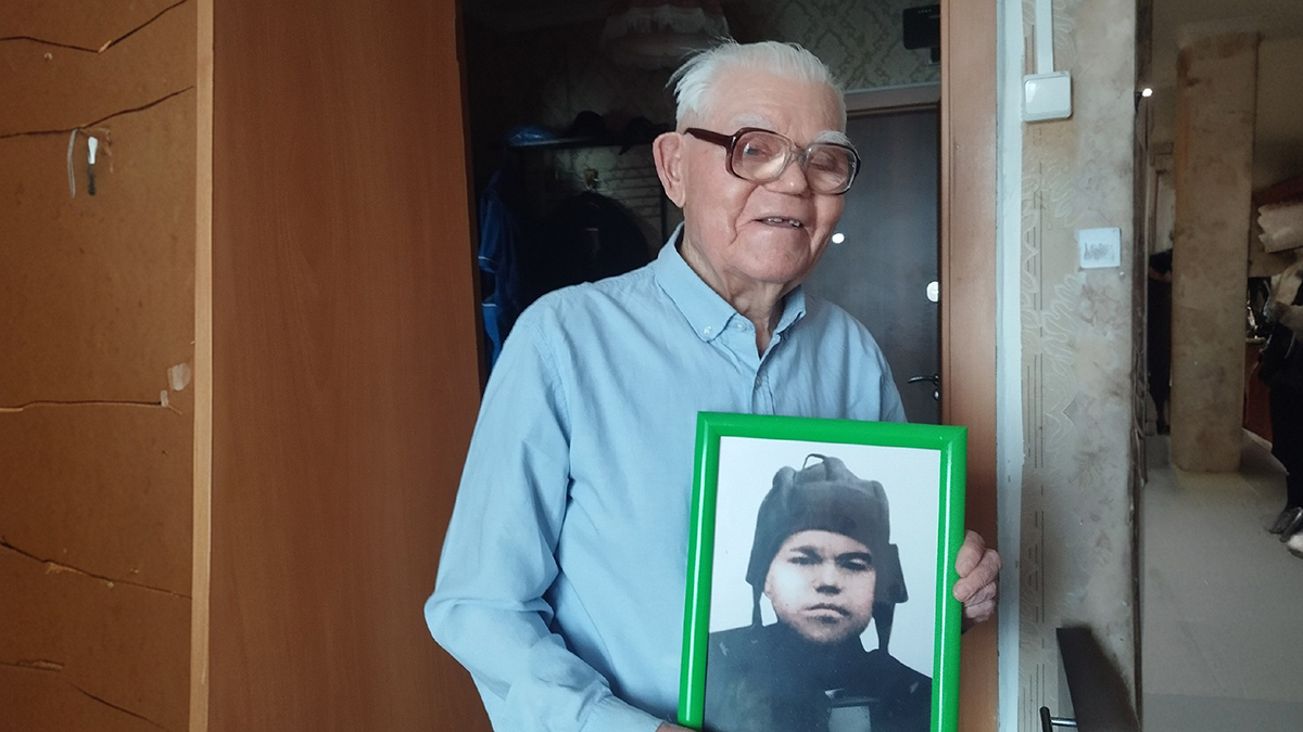 Николай Петрович Теплотанских позирует со своей военной фотографией. Сейчас ему 99 лет. А когда началась Великая Отечественная война, Коле было всего-то 16. Он участвовал в боях за Кенигсберг, участвовал в освобождении Вильнюса, воевал за Каунас