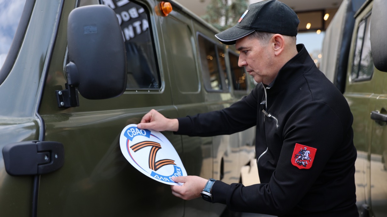 Префект СВАО Сергей Мельников наклеивает на УАЗ логотип благотворительной программы «СВАО для СВОих». Благодаря инициативе жителей округа и местных депутатов на фронт регулярно отправляются партии гуманитарных грузов, а в этот раз — еще и восемь автомобилей