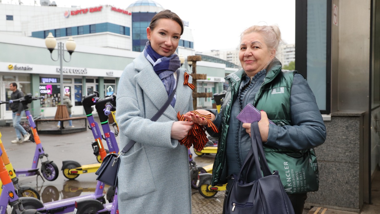 Волонтер Мария Комарова вручает ленту пенсионерке Елизавете Твердохлебовой