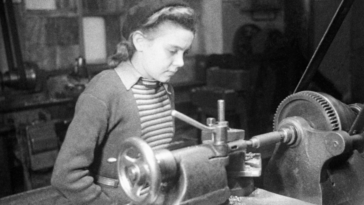 Юная учащаяся школы фабрично-заводского обучения работает за станком на столичном заводе