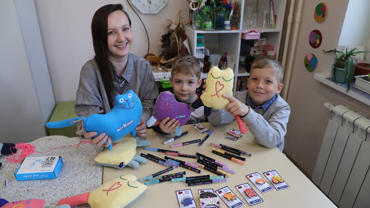 Анна Алешина вместе со своими сыновьями Максимом и Степаном (справа) показывают котов, которые уже готовы к отправке бойцам