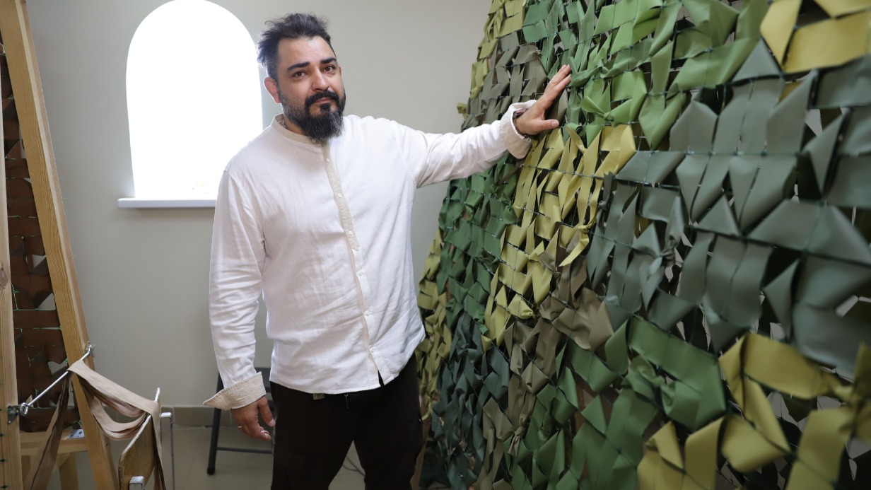 Основатель проекта «Ты Не Один», обладатель почетного знака отличия «Волонтер Москвы» Рачик Оруджев показывает маскировочные сети, изготовленные добровольцами. На лентах изделий волонтеры пишут молитвы с просьбой о защите бойцов