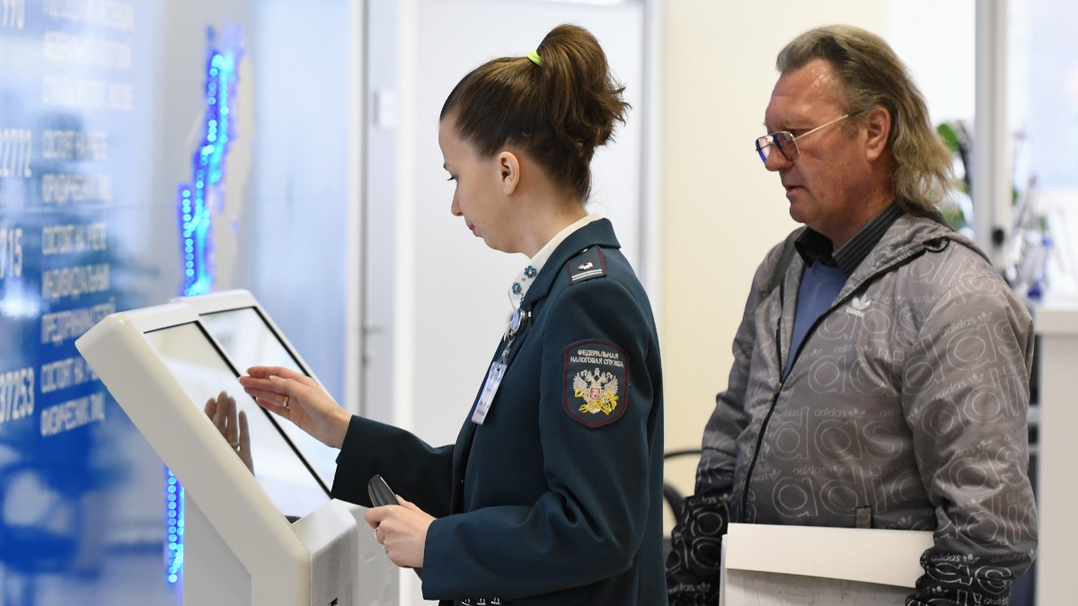 Сотрудница ФНС помогает посетителю со сдачей налоговой отчетности