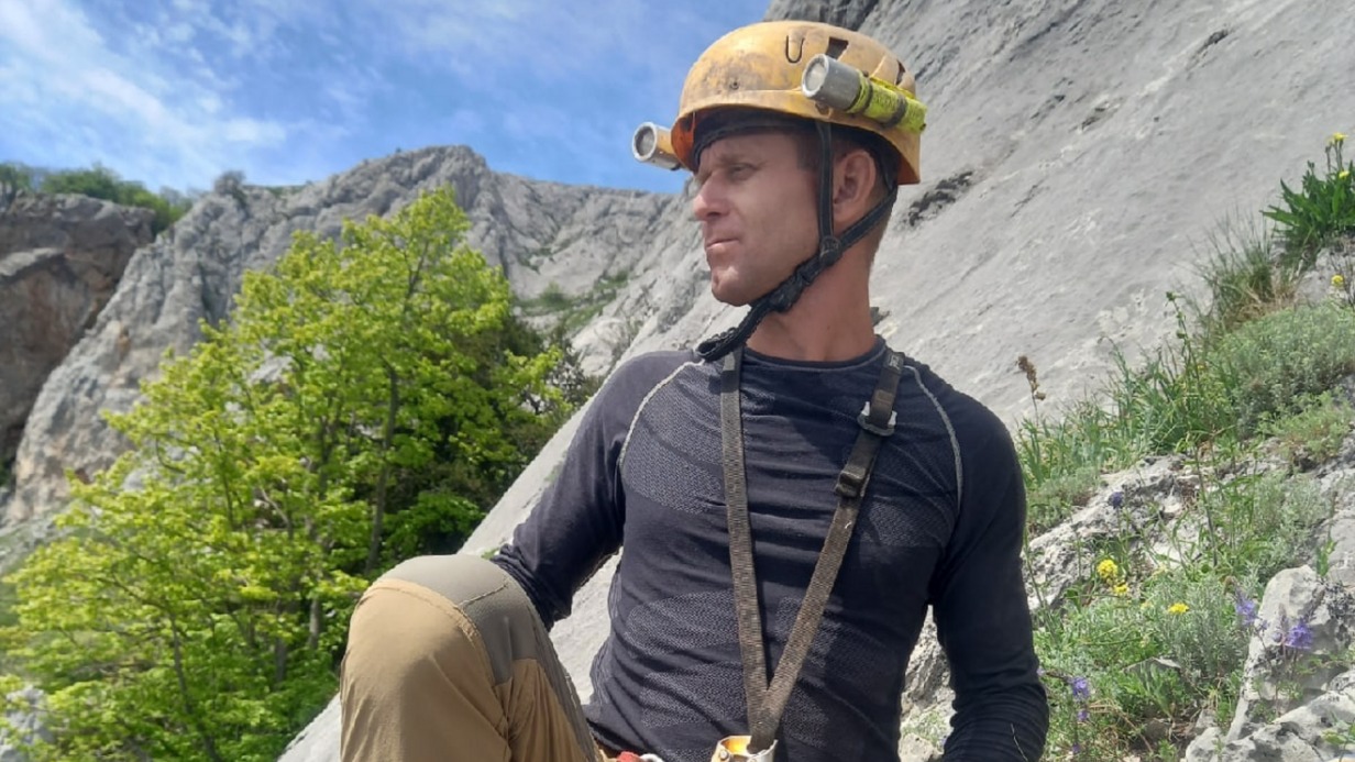 Руководитель Ассоциации спелеологов Севастополя Алексей Акимов возле пещеры Медовая над Мисхором в экипировке для безопасного спуска под землю