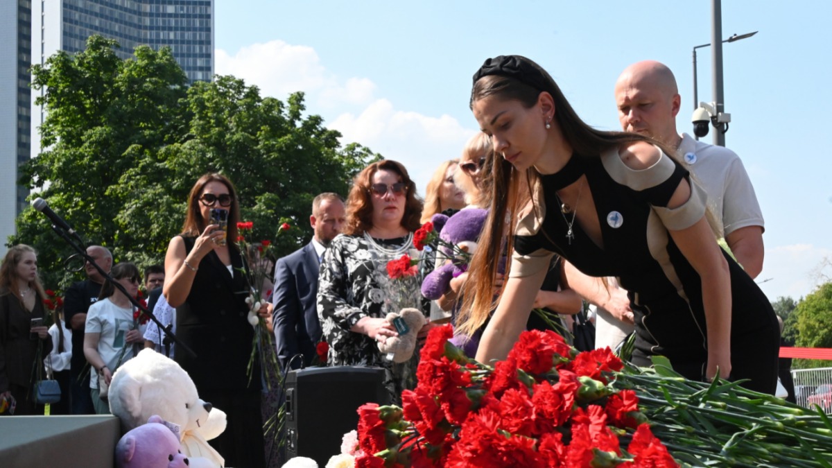 Участница акции памяти, вдова погибшего офицера ВС РФ Алана Цховребова возлагает цветы у мемориала с именами жертв националистического украинского режима