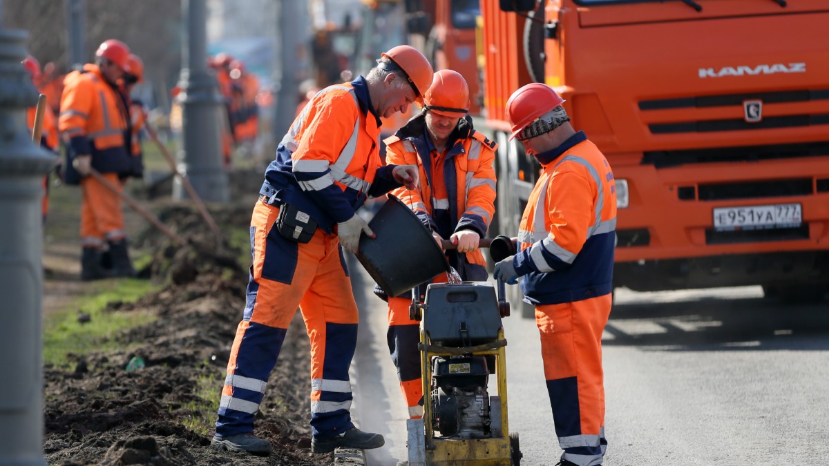 Сотрудники ГБУ «Автомобильные дороги» во время работ по замене бордюрного камня на Дмитровском шоссе в столице. Сегодня в городе 80 масштабных проектов по благоустройству дорог и дворов вдоль них