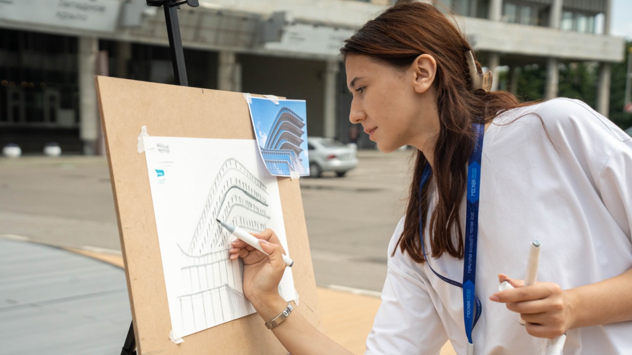 Дарья Старкова проводит для гостей фестивальной площадки в парке искусств «Музеон» мастер-класс по урбанистическому скетчингу — технике быстрого рисования городских пейзажей
