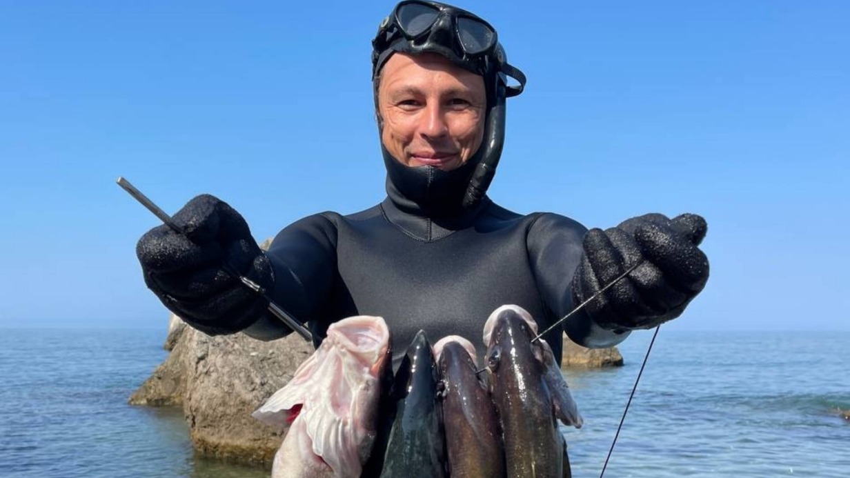 Севастополь, бухта Ласпи. Ныряльщик Вячеслав Кулешов демонстрирует результаты подводной охоты в Черном море