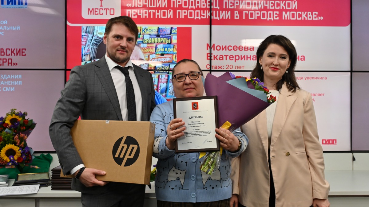 Генеральный директор АО «Мосгорпечать» Роман Бабин и заместитель исполнительного директора Союза предприятий печатной индустрии (ГИПП) Елена Чагина награждают победительницу конкурса «Московские мастера» Екатерину Моисееву