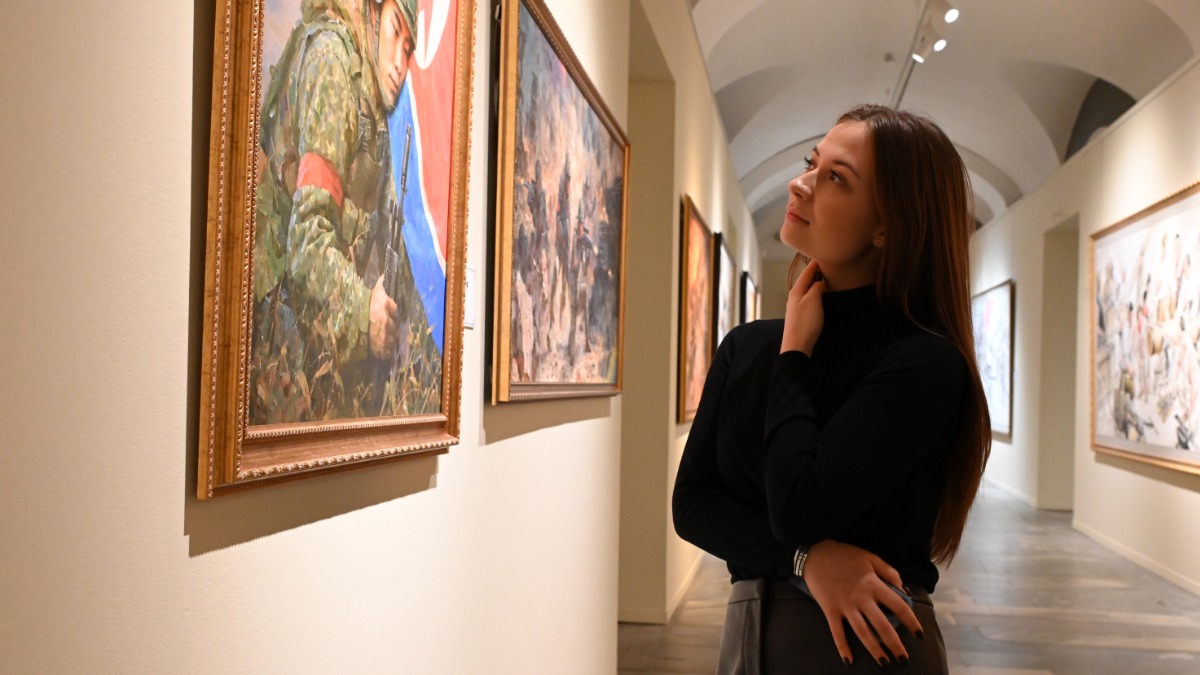 Москвичка Владислава Иванова у картины Ким Чон Чхана «Сыновья Родины», на которой солдат отдает честь флагу страны