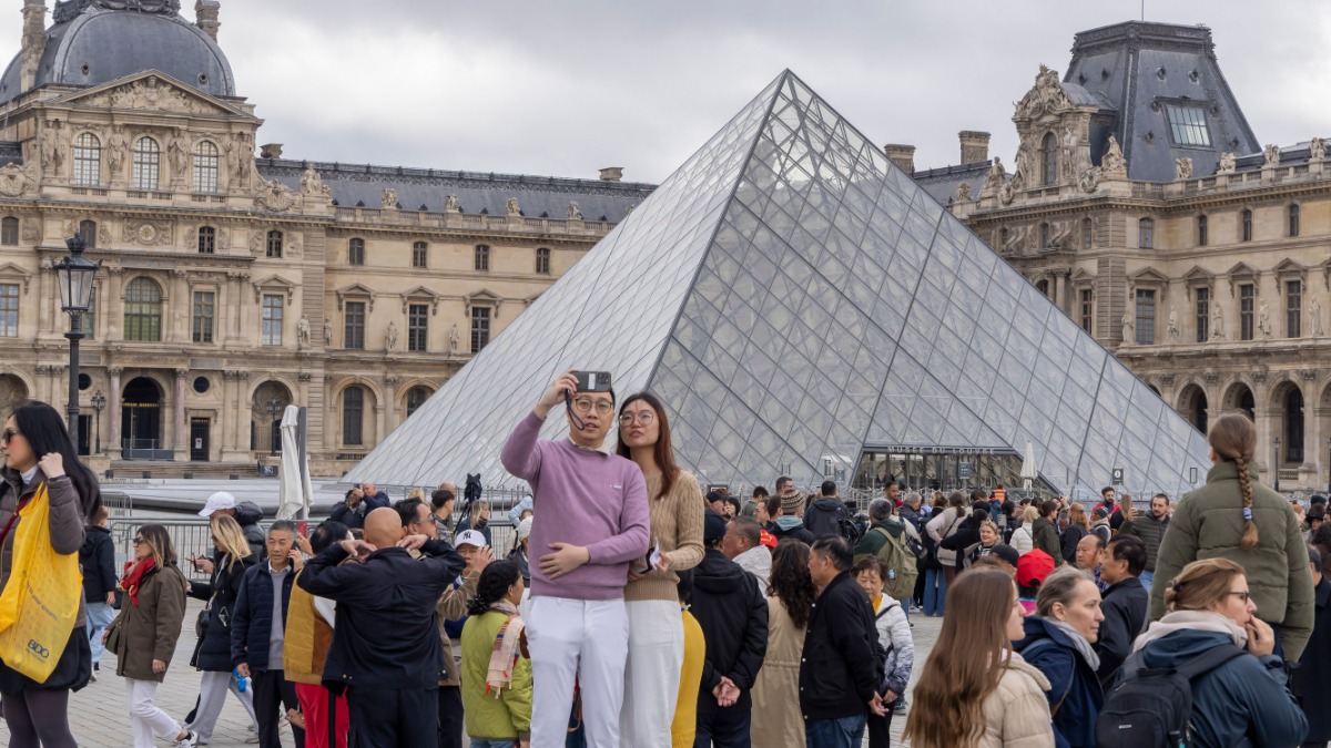 Парижане проходят мимо Лувра, где накануне произошло ограбление
